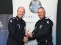 Assistant Commissioner Russell Barrett recognises Acting Senior Sergeant Tim Hart for his 40 years of service. Picture supplied