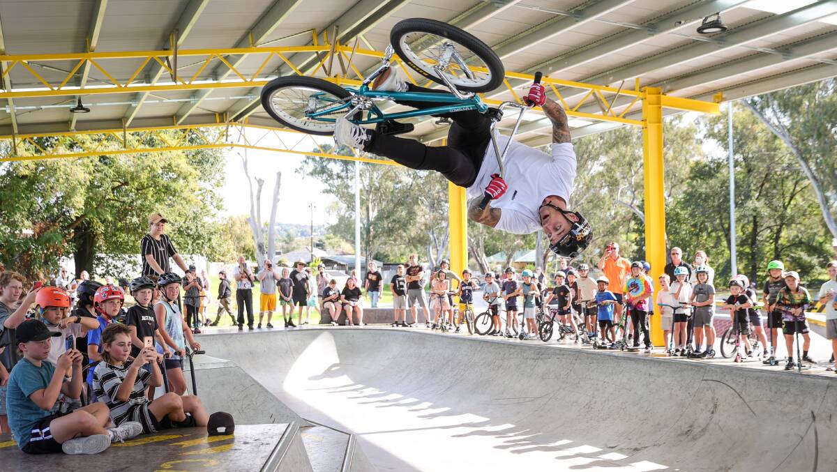 UPSIDE DOWN: Olympic BMX rider and Gold Medal winner Logan Martin wows hundreds of children at the new Albury skatepark on Thursday afternoon. Picture: JAMES WILTSHIRE
