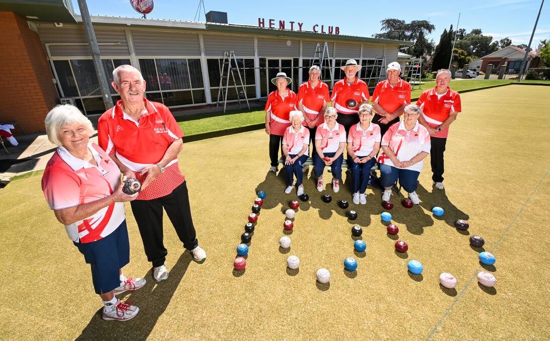 HISTORIC: Ladies president Allison Scott and mens president Gary Kern with their club-mates on the green at Henty. Picture: MARK JESSER
