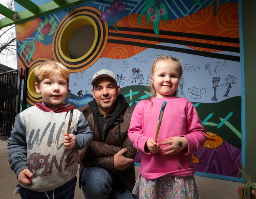 Wiradjuri artist Mick Bogie along with Lachlan O'Brien and Mila Rollason, both 4, are excited about the mural. Picture by James Wiltshire
