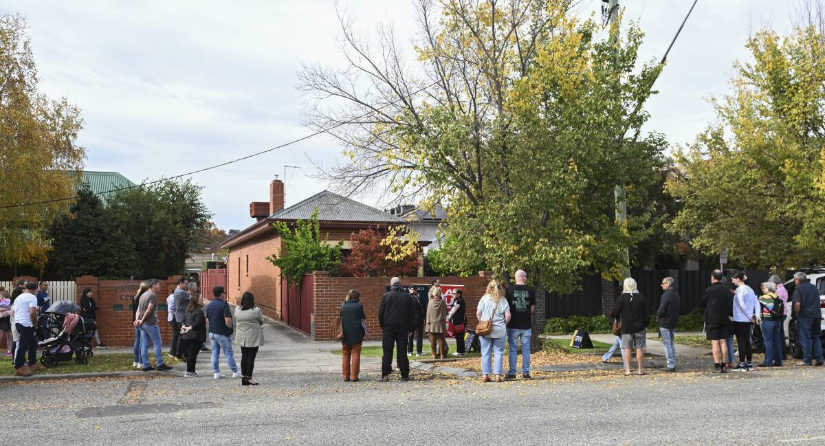 About 40 gathered at 438 Olive Street for the auction of a red brick house on Saturday, May 11. Picture by Mark Jesser