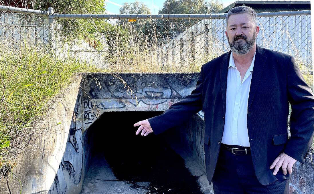 The escape route ... Darren Cameron says when police arrive at the reserve to respond to a complaint, many youth use this drain to flee. Picture by Ted Howes