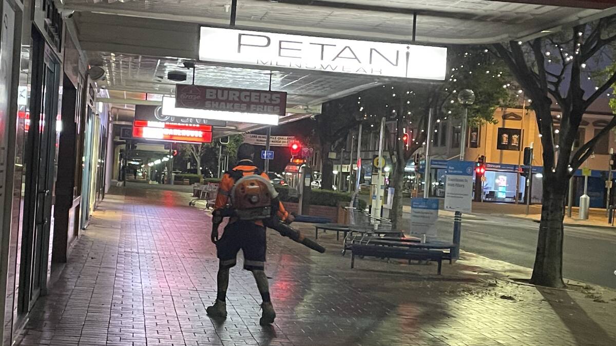 An Albury council worker blows leaves off the deserted Dean Street footpath into the gutter in the early hours of the morning across from QEII Square. A nearby cafe worker remarked, "He's just doing his job." Picture by Ted Howes