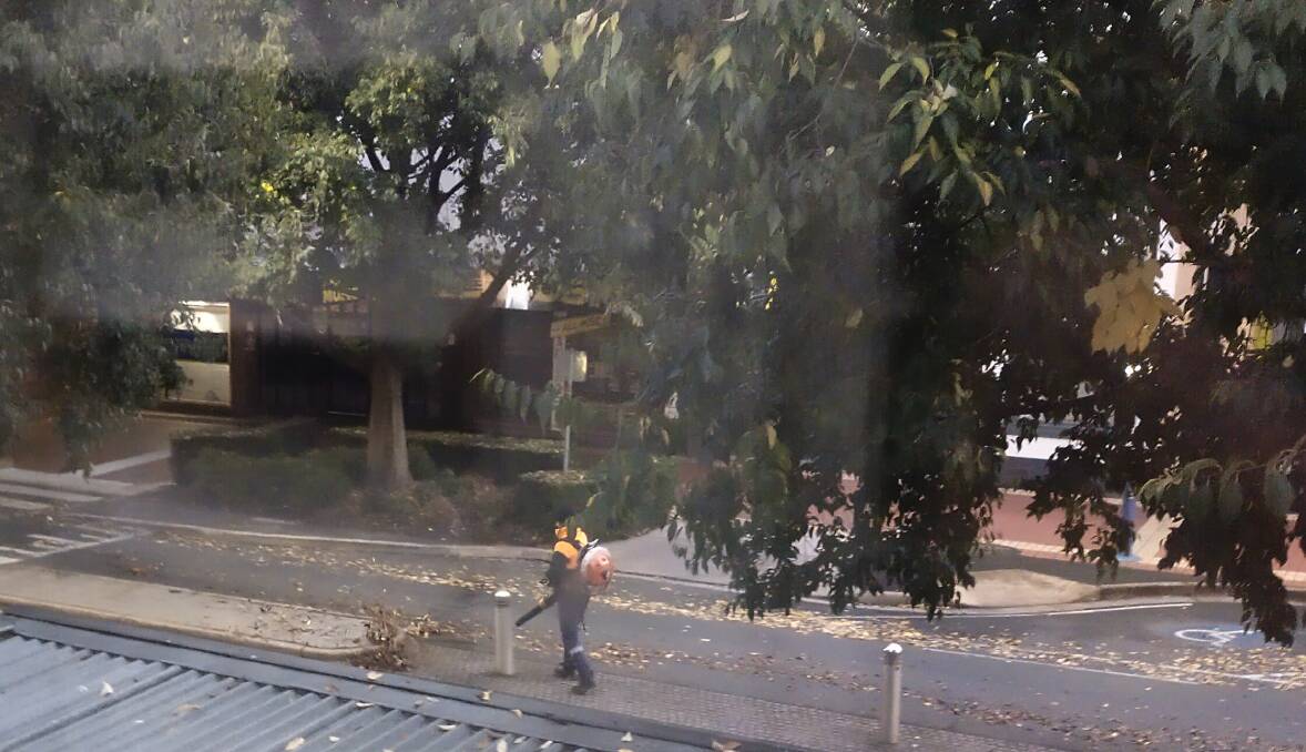 A leaf blower cleans up the western end of Dean Street across the road from All Music. 