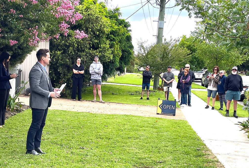 Auctioneer Lachlan Hutchins passes in a weatherboard home on Olive Street, South Albury, for $460,000. About 20 people turned up at the auction, about three of them said to be registered bidders. Picture by Ted Howes