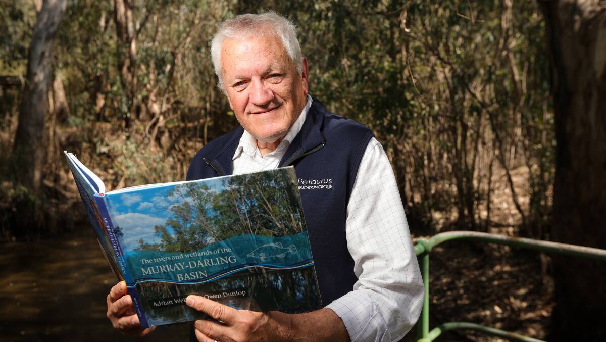 Author Adrian Wells at Wonga Wetlands with his book, The Rivers and Wetlands of the Murray Darling Basin, that he co-authored with former principal Owen Dunlop. Picture by James Wiltshire