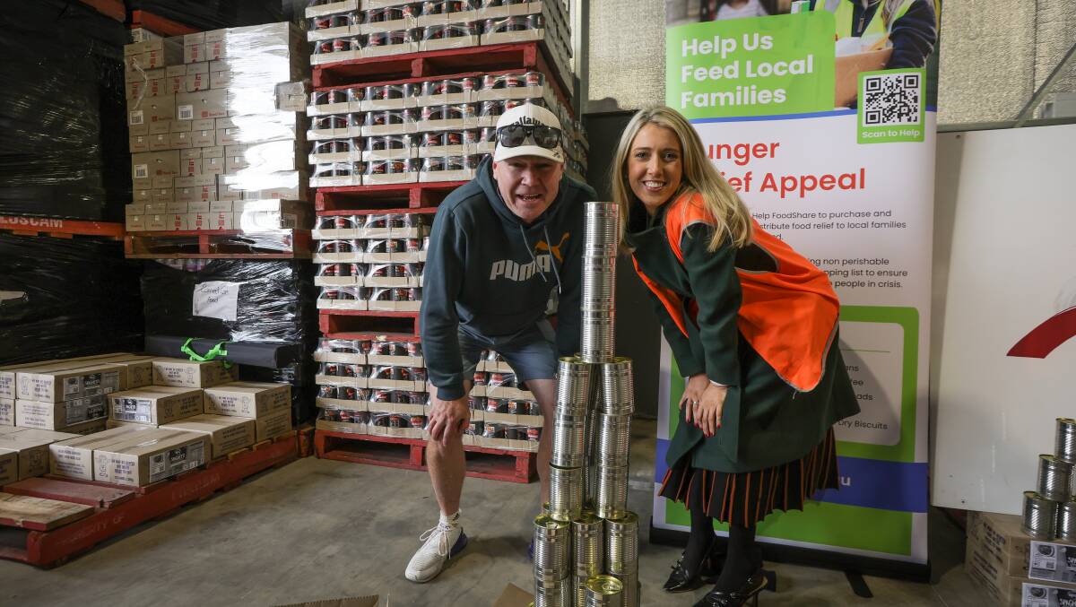 Channel 7's Reece Rayner and Jacqueline Stanley with their winning can tower. Picture by James Wiltshire