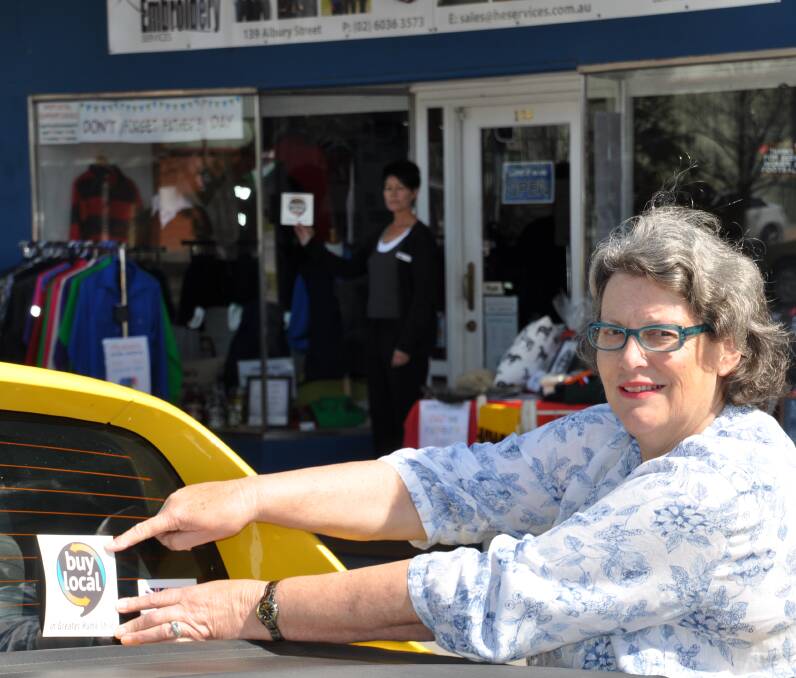LOCAL VOICE: Greater Hume Shire councillor Heather Wilton demonstrates her support for the council's Buy Local campaign launch, at Walla Walla this week, showcasing a decal sticker available. Picture: MARGARET KILLALEA