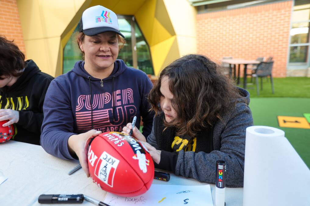 Karlyn Boyer and her son Jackson Davis, 10, who is painting a football that will be auctioned to raise money and awareness for Terry Socks It To Cancer. Picture by James Wiltshire