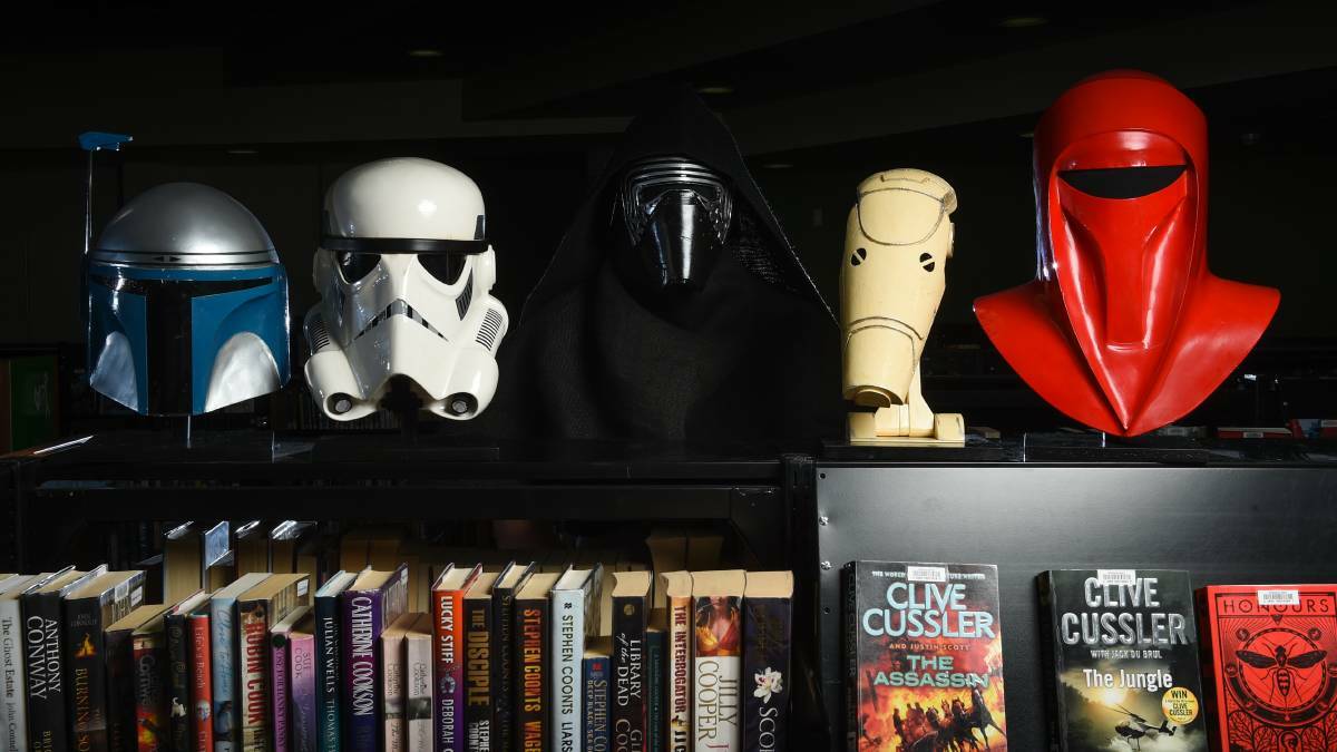 STAR CRAFT: Star Wars helmet maker Michael Callahan dressed as new villain Kylo Ren with his creations in the Wodonga Library. Picture: MARK JESSER