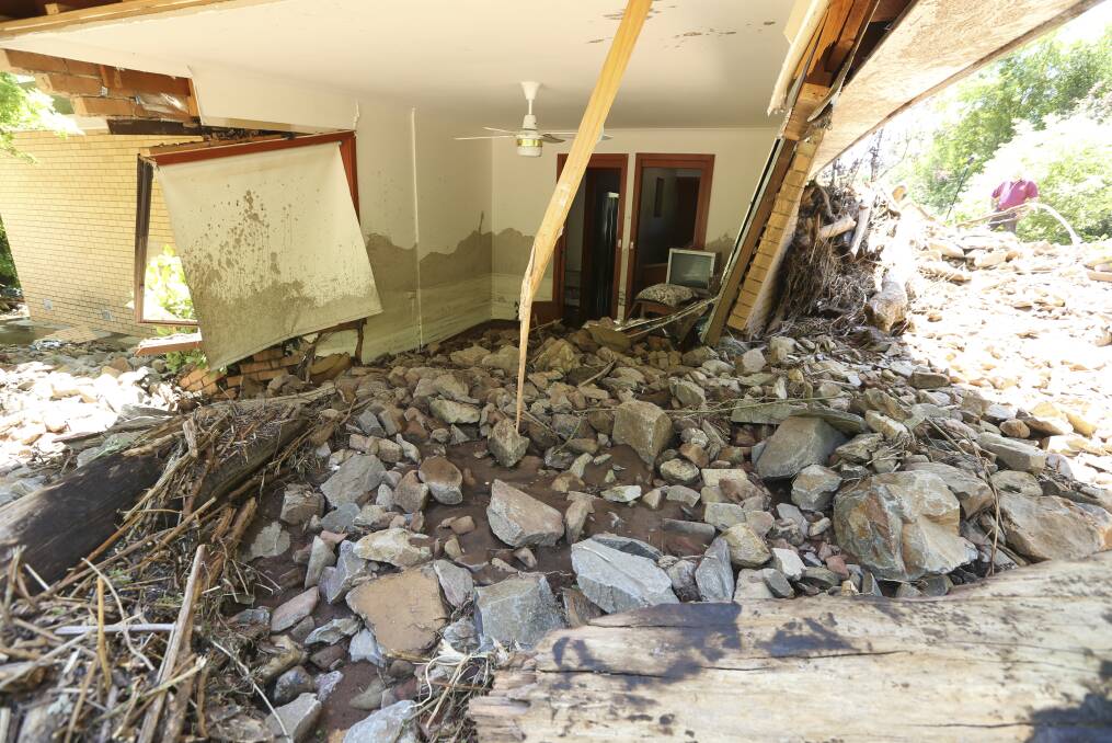 HIGH COST: Alpine Shire is counting the damage bill from the landslip, which took out two homes in Ovens with rocks and debris, plus rain and hail, which flooded roads. Pictures: ELENOR TEDENBORG