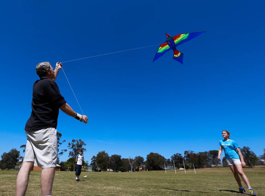 Sunny spring: Nigel Matthews of Thurgoona with grandchildren Toby Spinks, 8, and Amelia Spinks, 10, of East Albury flying their kite. Picture: MARK JESSER