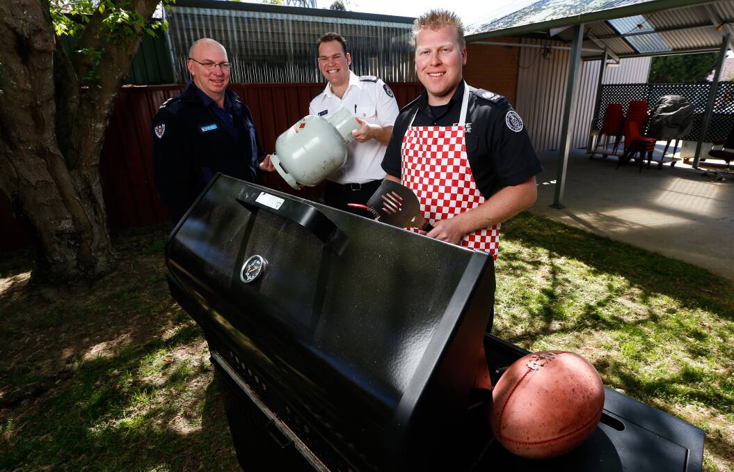 Cooking with gas: NSW station officer Dean Campbell, NSWRFS district officer Charles Anderson and CFA operations officer Brett Myers want people safe around the barbecue on grand final day. Picture: MARK JESSER