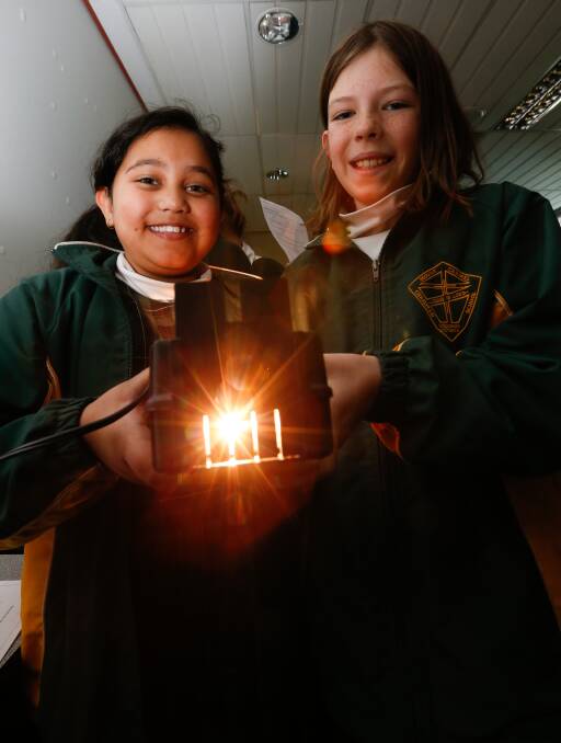 BRIGHT SPARKS: Mount Carmel Primary School grade 5 students Jadyn Snell, 9, and Eden McIntosh, 10, learn about curved mirror lenses on Tuesday. Picture: MARK JESSER