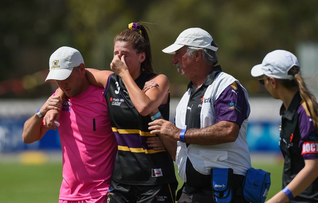 Murray Bushrangers' Olivia Barber being helped off the field after a head knock during the game in Wangaratta on Sunday. Pictures: MARK JESSER