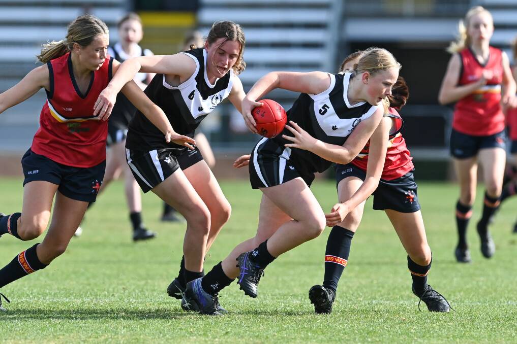 FOCUSED: Albury's Blaize Seymour makes a run for it with help from Leah Smith of Narrandera. Picture: MARK JESSER