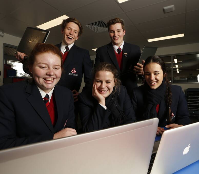 TECHNOLOGY ADVANCEMENT: Trinity Anglican College students Kaitlyn Wheeler, 17, Bailey Waters, 16, Mia Zitzlaff, 17, Jake Dicketts, 17, and Shannon Fenn, 17, look at their laptops. Picture: MARK JESSER

