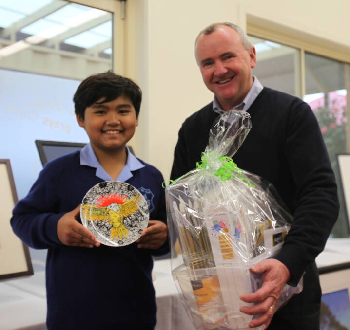 CHUFFED: Grade 5 student Natt Watnatawaphat, 11, who won St Augustine art show's student category, with his principal, Joe Quinn. Natt moved to Australia this year from Thailand with his family.