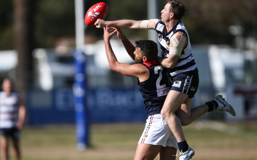 FLYING HIGH: Yarrawonga's Craig Ednie punches the ball away from Raider Dean Heta at J.C. Lowe Oval. Picture: JAMES WILTSHIRE