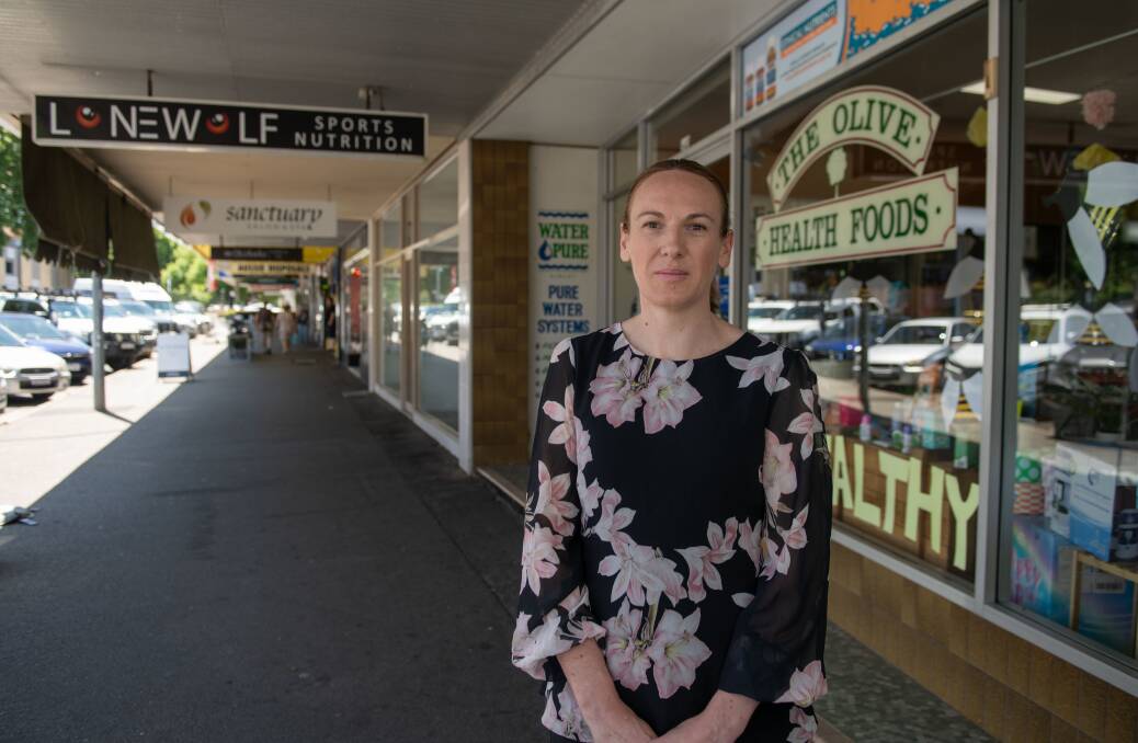 Olive Health Foods proprietor Rachael Hart outside her shop with proposed site of a strip club in the background facing the Sanctuary sign. Picture by Tara Trewhella