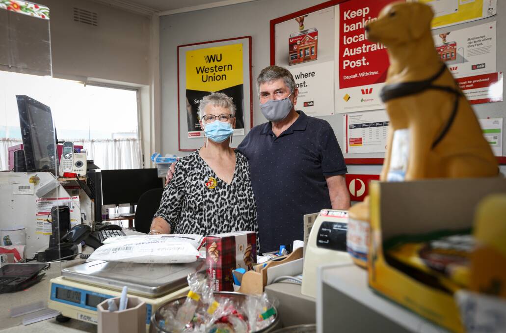 End of an era: Shirley and Jim Crawford in their store with masks on as part of COVID protocols which also seen a perspex screen erected on their counter. Picture: JAMES WILTSHIRE