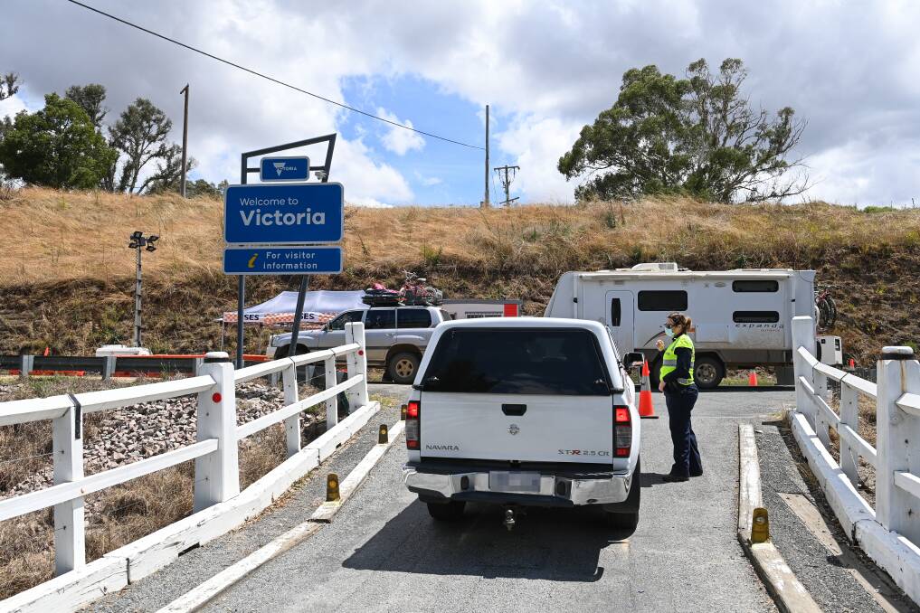 Going: The timber Towong bridge across the Murray River is being replaced. This photograph was taken nearly a year ago when Victoria put checkpoints on crossings as part of a New Year's Eve shutdown.
