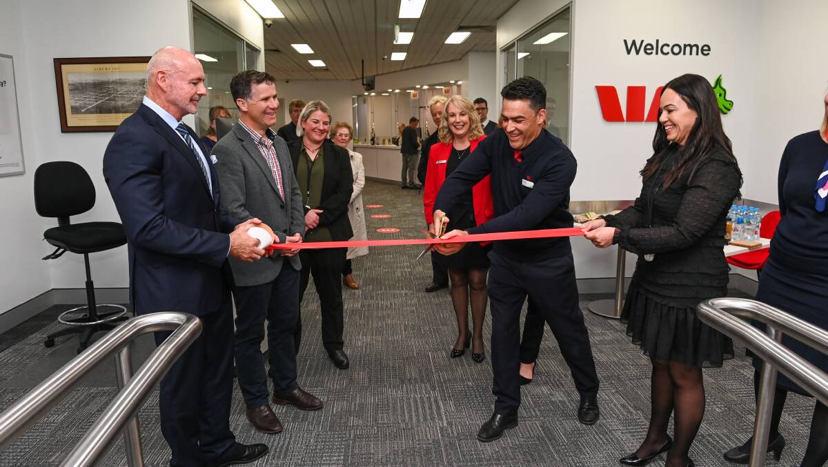 Ross Miller and Westpac NSW regional state general manager Diana Diab hold the ribbon as Albury branch manager Paul Gow cuts it to mark the opening of the rebranded outlet. Picture by Mark Jesser.