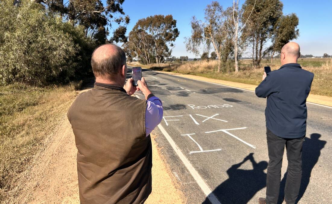 Ovens Valley MP Tim McCurdy and his Nationals colleague and the Opposition's roads spokesman Danny O'Brien take photos of graffiti urging repairs on the patched up Wangaratta-Yarrawonga Road. 