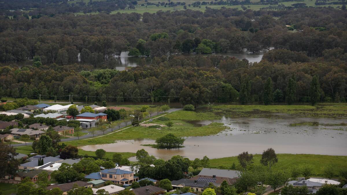 Water fans out across the flood plain towards homes at the southern end of the Eastern View Estate in East Albury on Sunday afternoon. The swollen Murray River can be seen in the background. Picture by James Wiltshire.