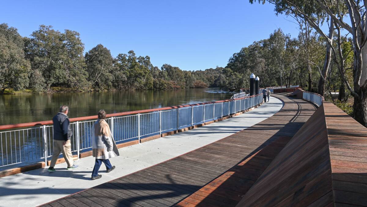 Walkers enjoy the new boardwalk along the Murray River in Albury which is designed to attract visitors and locals to the waterway. Picture by Mark Jesser