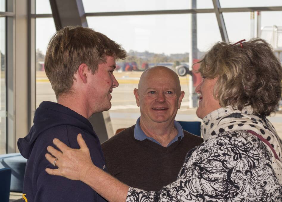 Wangaratta's James Long is greeted by his parents Tim and Liz. Mrs Long presented flowers to Kellie Kadaoui who co-ordinated the effort to find a way home after the collapse of Air Vanuatu. Picture by Layton Holley 