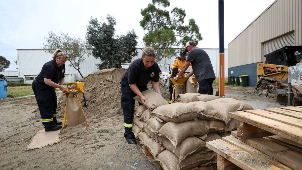 Dedicated volunteers fill out bags with sand at the Thurgoona base of the Albury SES unit. Picture by James Wiltshire.