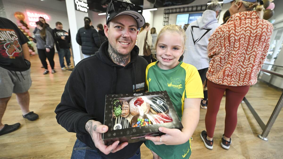Ben Keith and his daughter Addison with their donuts ready to take home after being among the throng for the first day of trading at Daniel's Albury shop. Picture by Mark Jesser