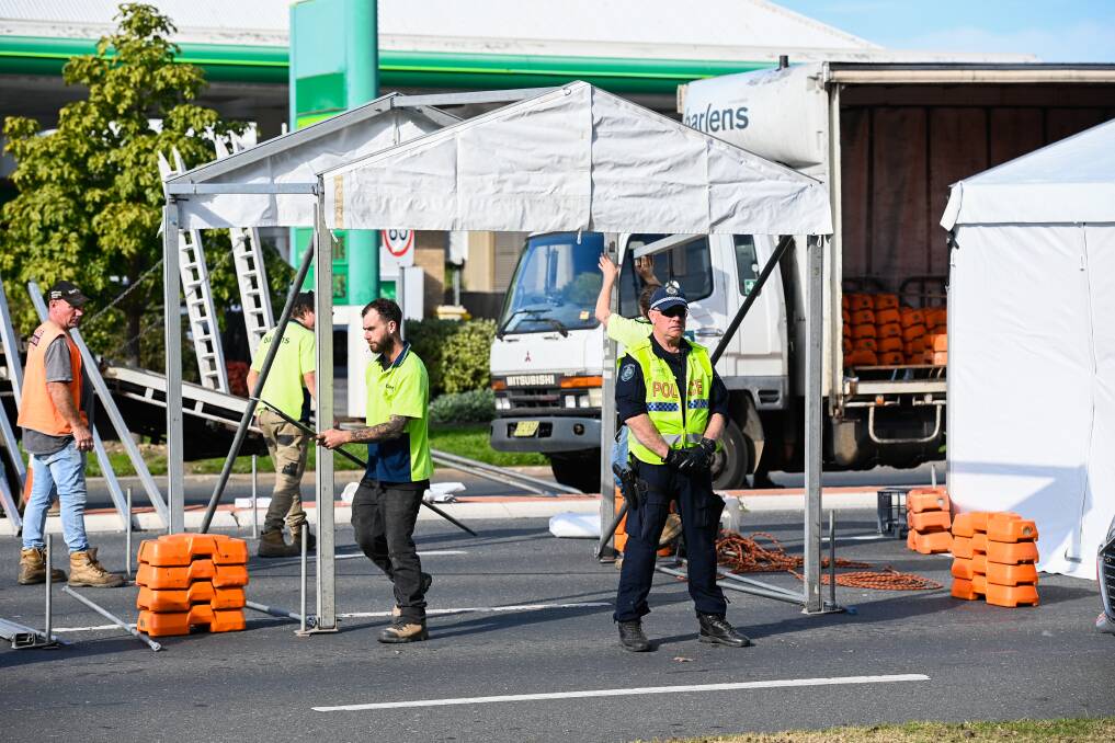 Go go go: Hire firm staff erect shelters in Wodonga Place to ensure police will be able to stay warm and dry. The police commissioner said Sydney police had also been given warmer clothing to combat the cold weather through the night. Picture: MARK JESSER