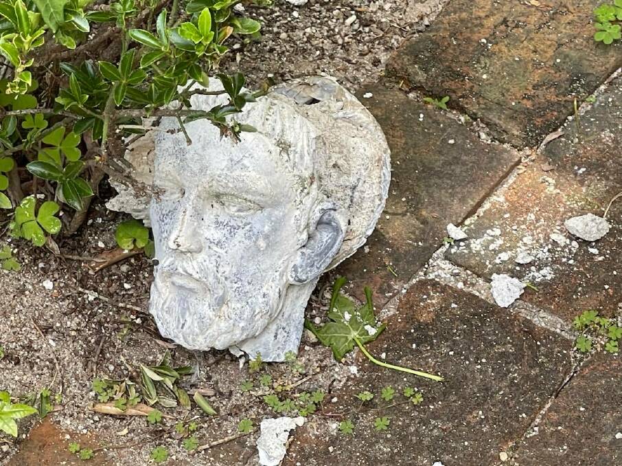 The moulded head of St Francis left on the ground after being broken off.