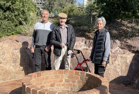 Les Boyes, pictured last year with his walker, between son John and wife Nancy behind a restored well on the former family farmland that now forms part of Clyde Cameron Reserve in southern Wodonga.