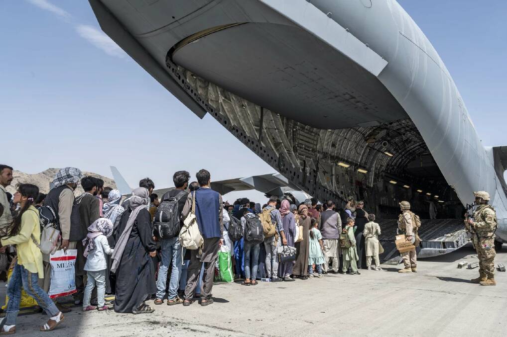 A US air force picture of Afghans fleeing Kabul in 2021 following the takeover of the capital by the Taliban.