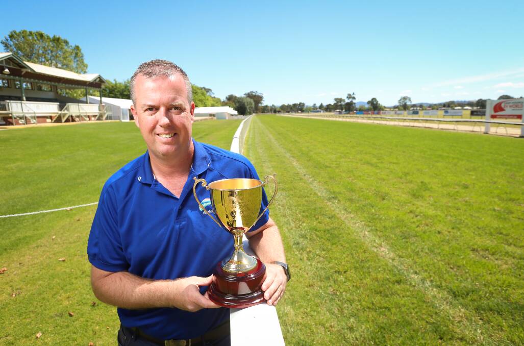 Racing Wodonga's Steve Wright stands in front of the historic grandstand with the Wodonga Gold Cup. There are long term plans to erect a function centre which could overlook the winning post. 