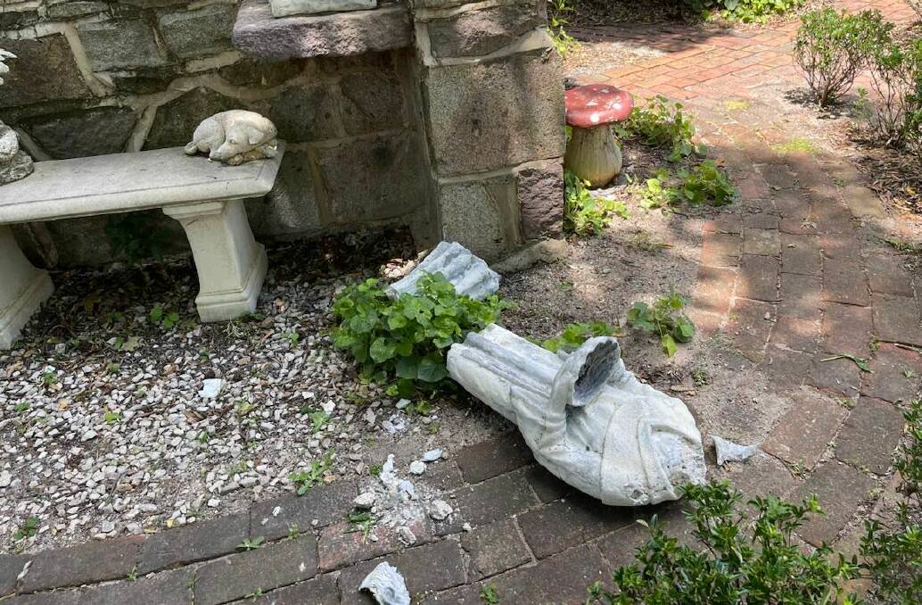 The body of the statue of St Francis of Assisi lies on the ground after being toppled from its base.