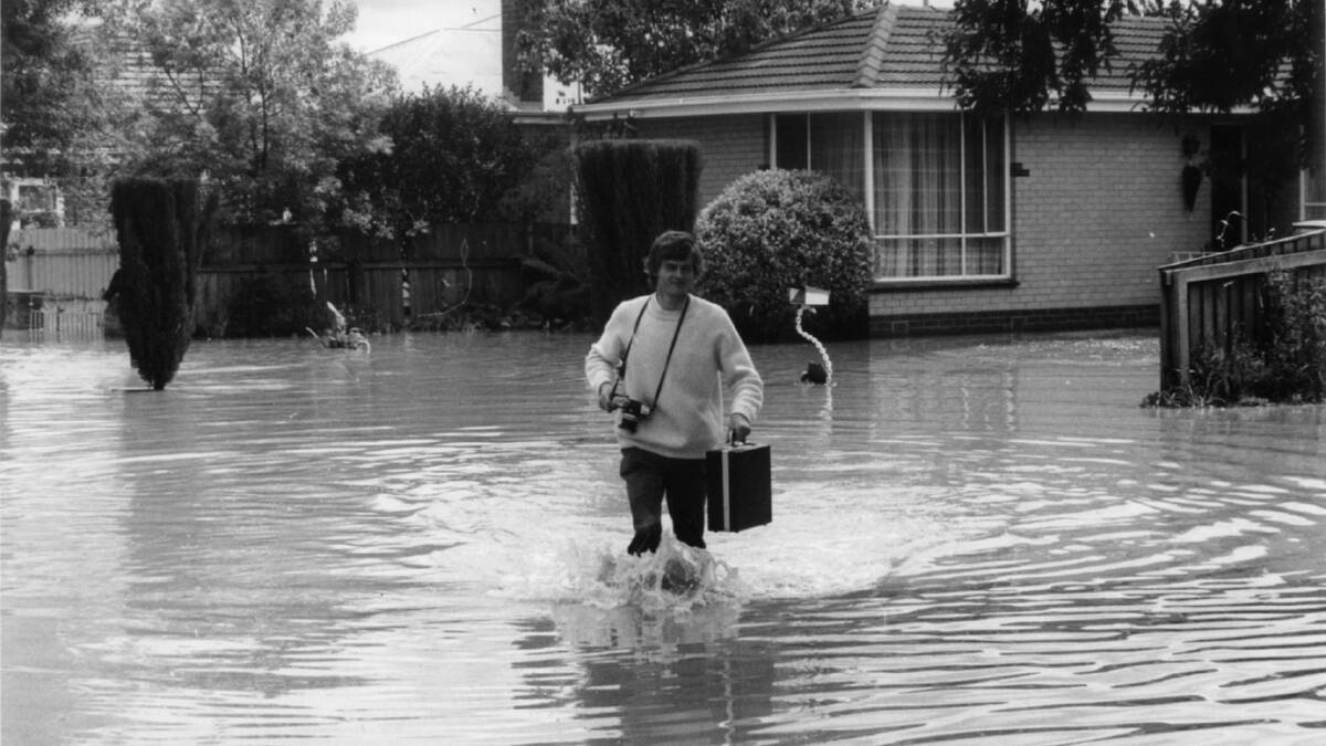 Flashback: Border Mail photographer Peter Merkesteyn wades through South Albury floods in 1975. The inundation was a regular occurrence before the strengthening of the levee parallel to the Murray River in the early 1990s.
