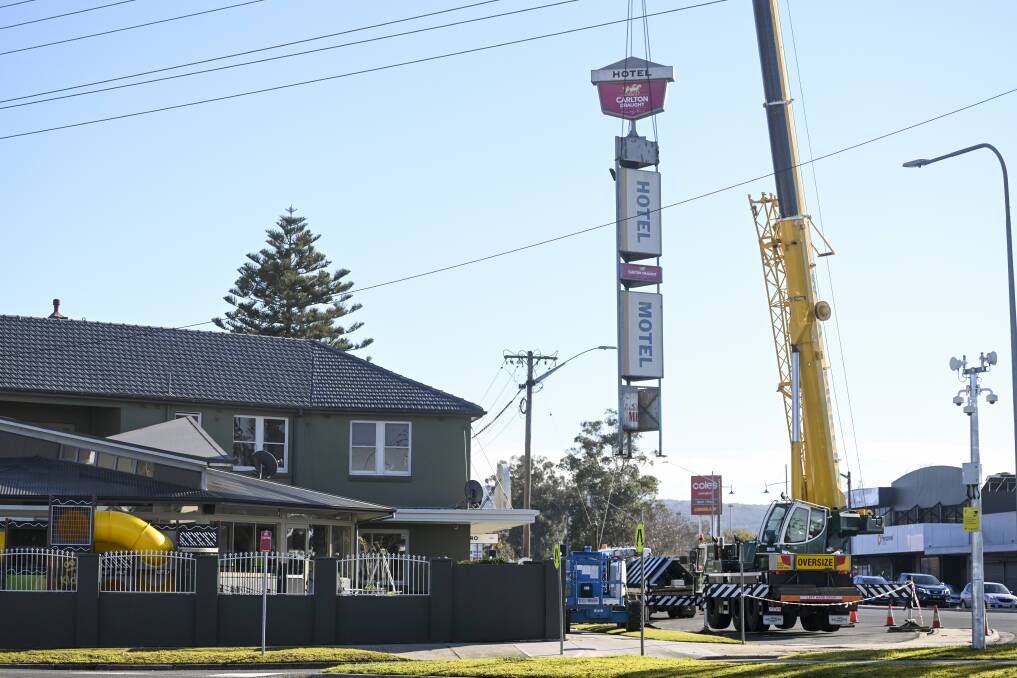 Up, up and away, the landmark hotel-motel sign, topped with a Carlton Draught advertisement, is lifted away from the Northside. Picture by Mark Jesser 
