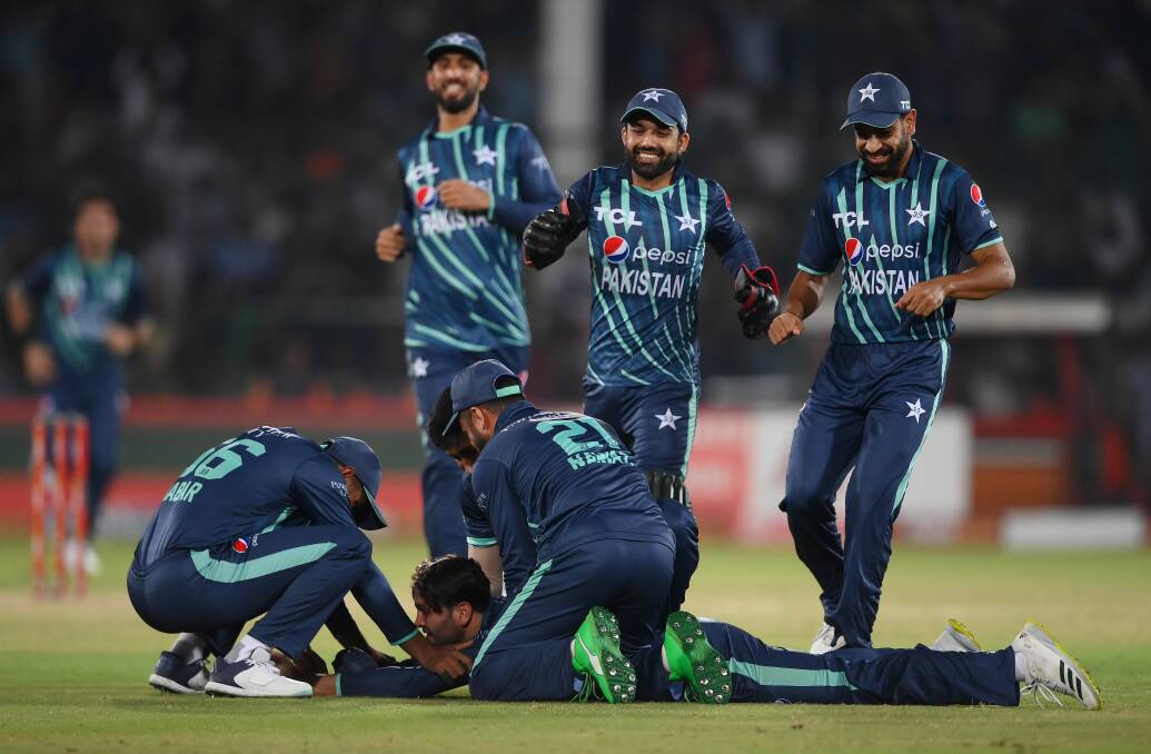 Usman Qadir (on ground) is congratulated by his Pakistan team-mates after taking a wicket at T20 level. Picture by Getty Images