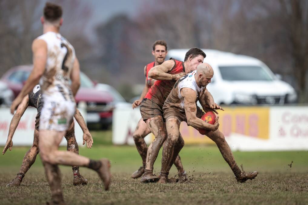 Ryan Crisp tries to steal possession from Wangaratta's Ben Reid a fortnight ago. It will be Myrtleford's first game back at home since that muddy clash.