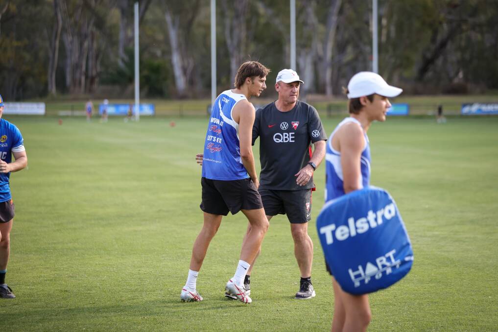 Sydney Swans' coach John Longmire gives a tip to emerging Roos' tall Ryan Eyers. Picture by James Wiltshire