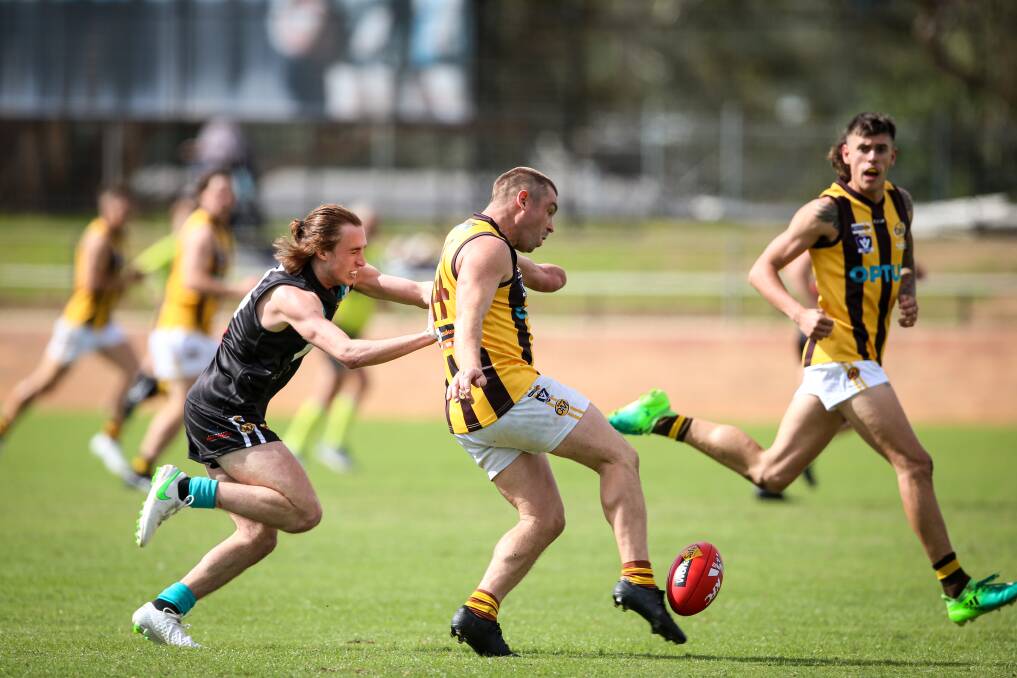 ROVERS WIN: Wangaratta Rovers' Sam Carpenter gets his kick away, despite the efforts of Lavington's Macca Hallows. Rovers won by 31 points. Picture: JAMES WILTSHIRE