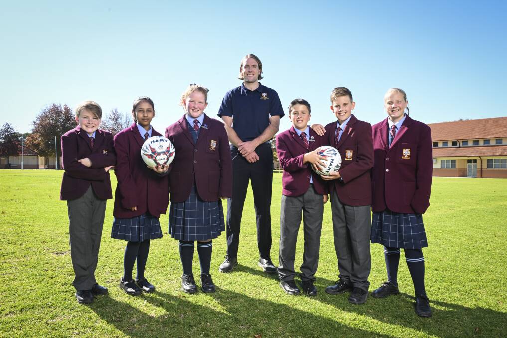 
Former AFL player Max Lynch is studying teaching and working at The Scots School Albury. He's now playing soccer and caught up with Jack Tonkin, 10, Haniya Ansari, 11, Evie Smith, 11, Isaac Kunde, 11, Duke Wilkerson, 11, and Olivia Trevethan, 12. Picture by Mark Jesser