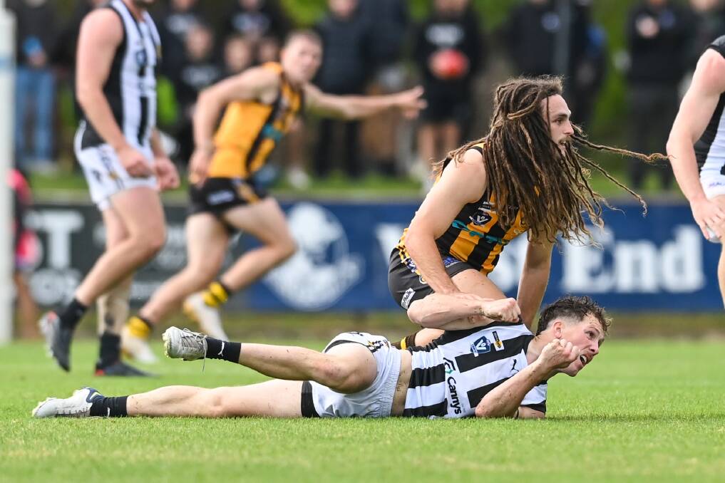Wangaratta Rovers' Will Nolan (top) and Wangaratta's Luke Saunders
watch the ball in the thrilling local derby on Good Friday.
Picture by Mark Jesser