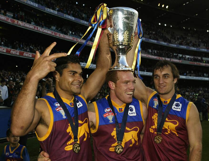 Mal Michael, Justin Leppitsch and Daniel Bradshaw get their hands on the 2003 premiership cup. Picture by Getty Images