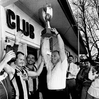 Wodonga coach Jeff Gieschen holds the premiership trophy aloft after the most talked about grand final in Ovens and Murray history, the 1990 decider between Wodonga and Lavington.