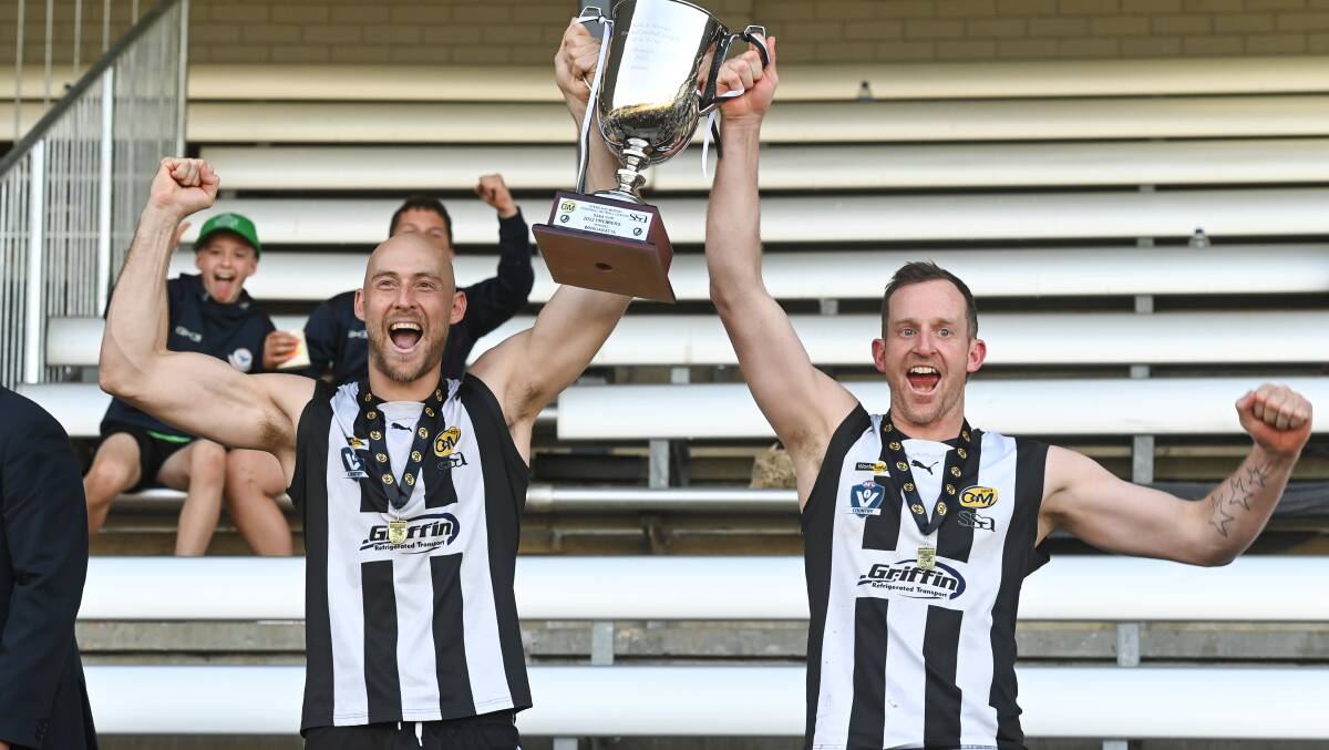 Magpie stars Ben Reid and Michael Newton with the premiership cup.